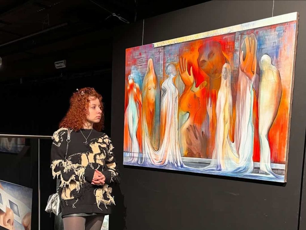 Artist standing beside her large-scale painting