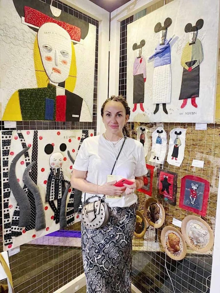 Artist at her stand of textile works
