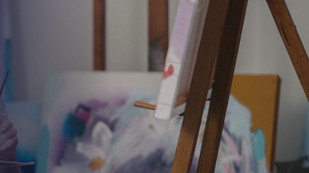 A painting on an easel in an artist’s studio